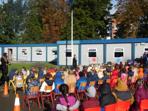 An scoil ar fad ag éisteacht le Muinteoir Sandra agus í ag labhairt faoi thábhacht na Gaeilge. 